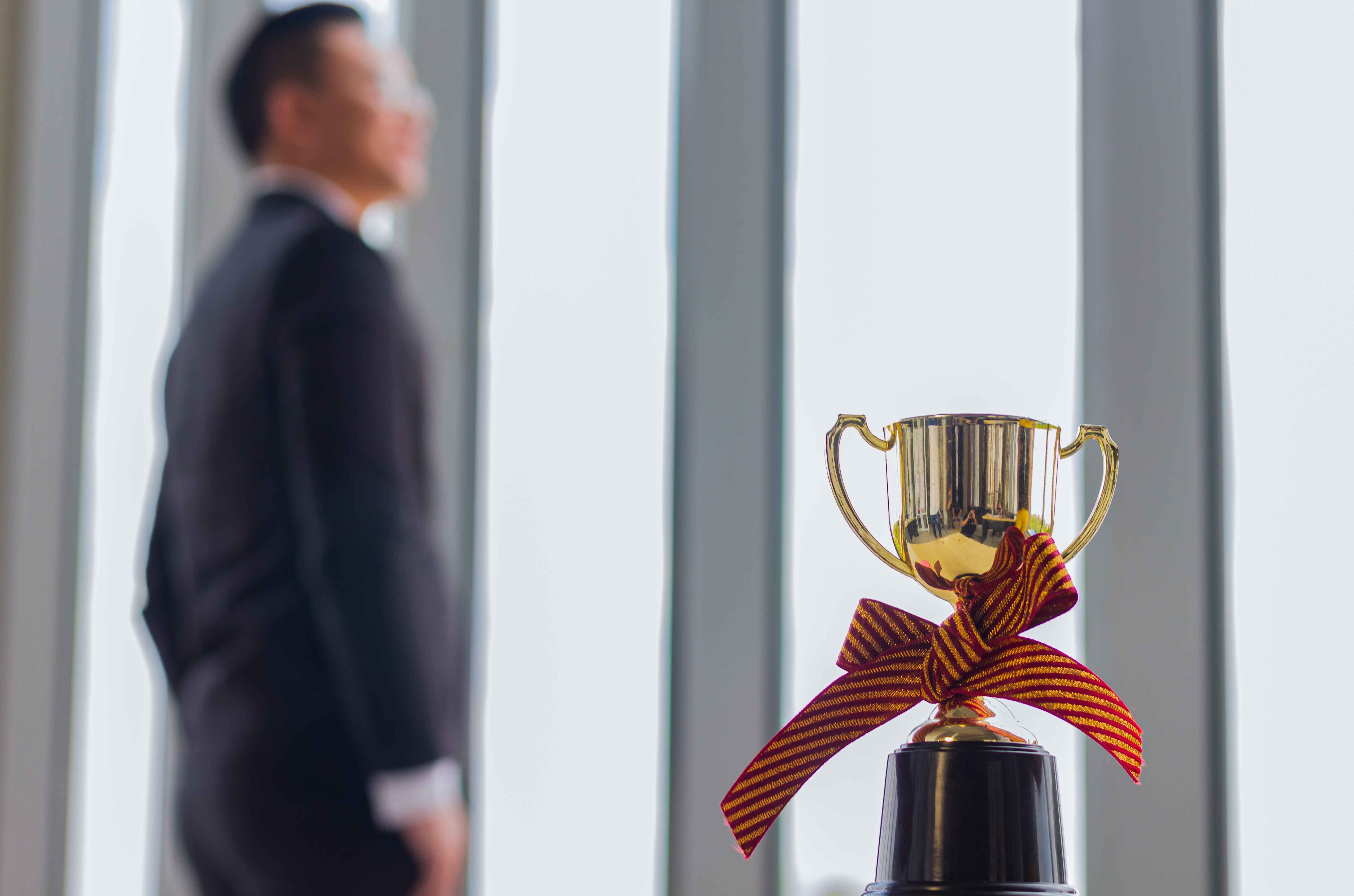 businessman-posing-near-an-award