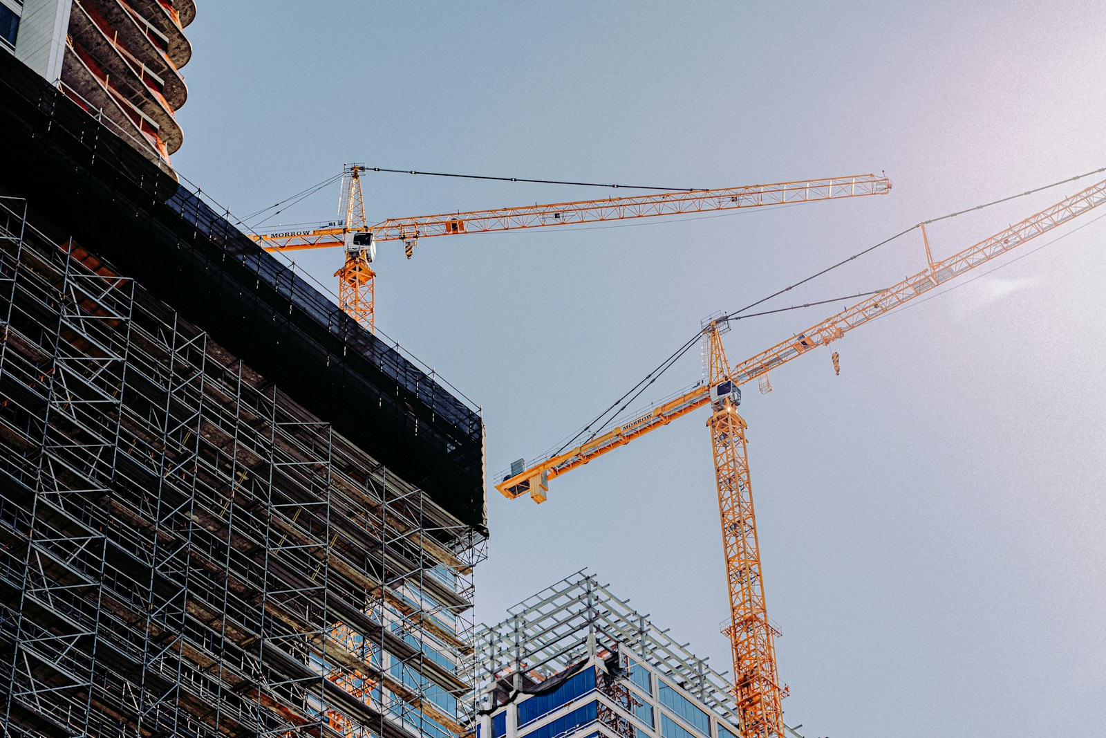 Building under construction with yellow crane during daytime.